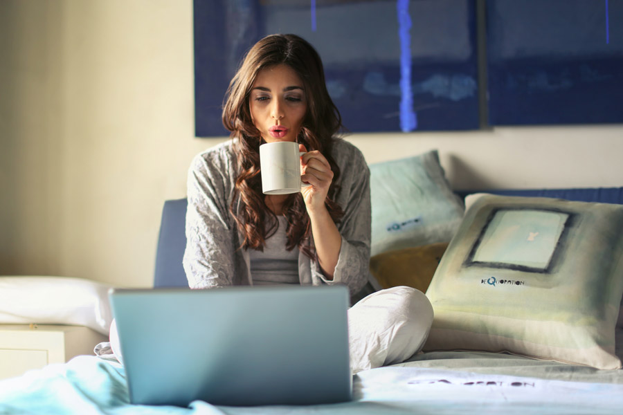 persona con ordenador y cafe en su cama - solicitar paro online - certificadoelectronico.es